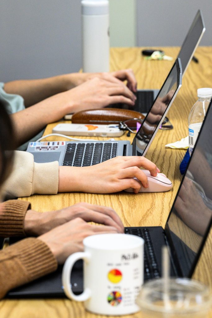 row of students typing on their laptops