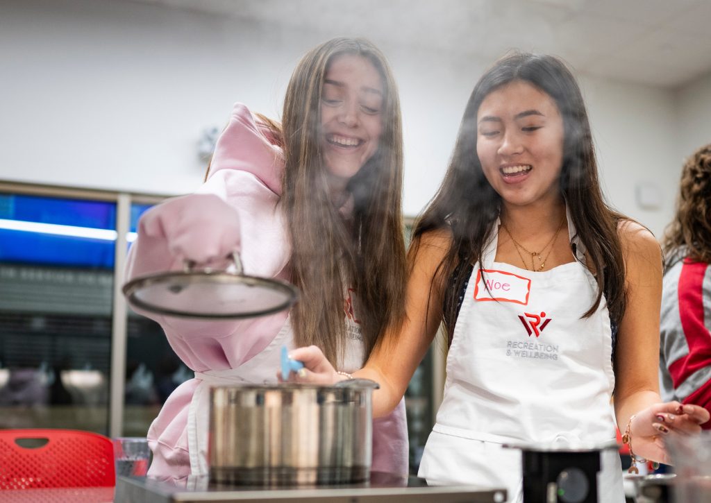 Students making soup, a puff of steam coming from the pot
